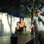 The couple plays a game of beer pong while their shadows play something else.