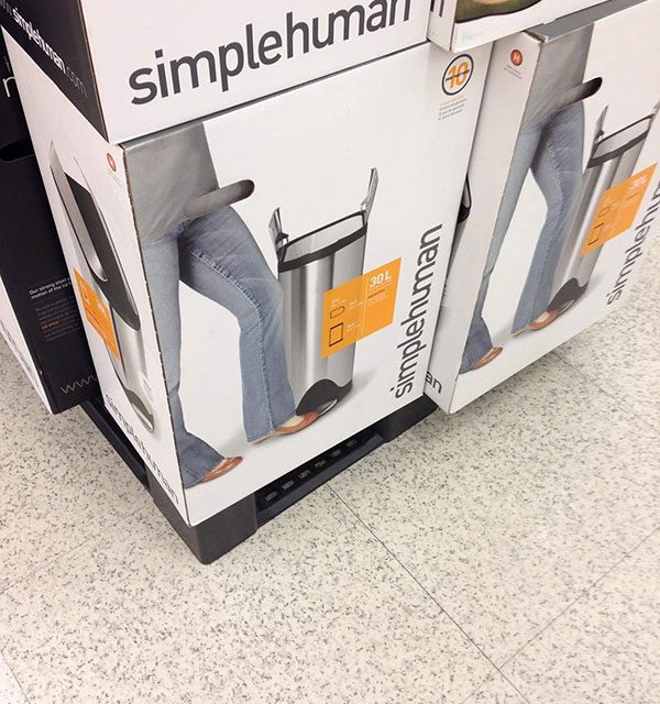 The handles of a box with a bin in it creates a sexy optical illusion. It looks like this lady got very excited about bins.