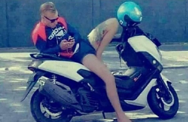 Guy leaning on his scooter looks like two people in an awkward situation