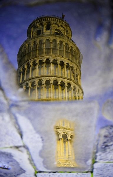 Pisa tower reflected in a puddle