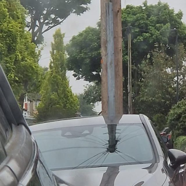 An optical illusion of a car windshield impaled by a large beam